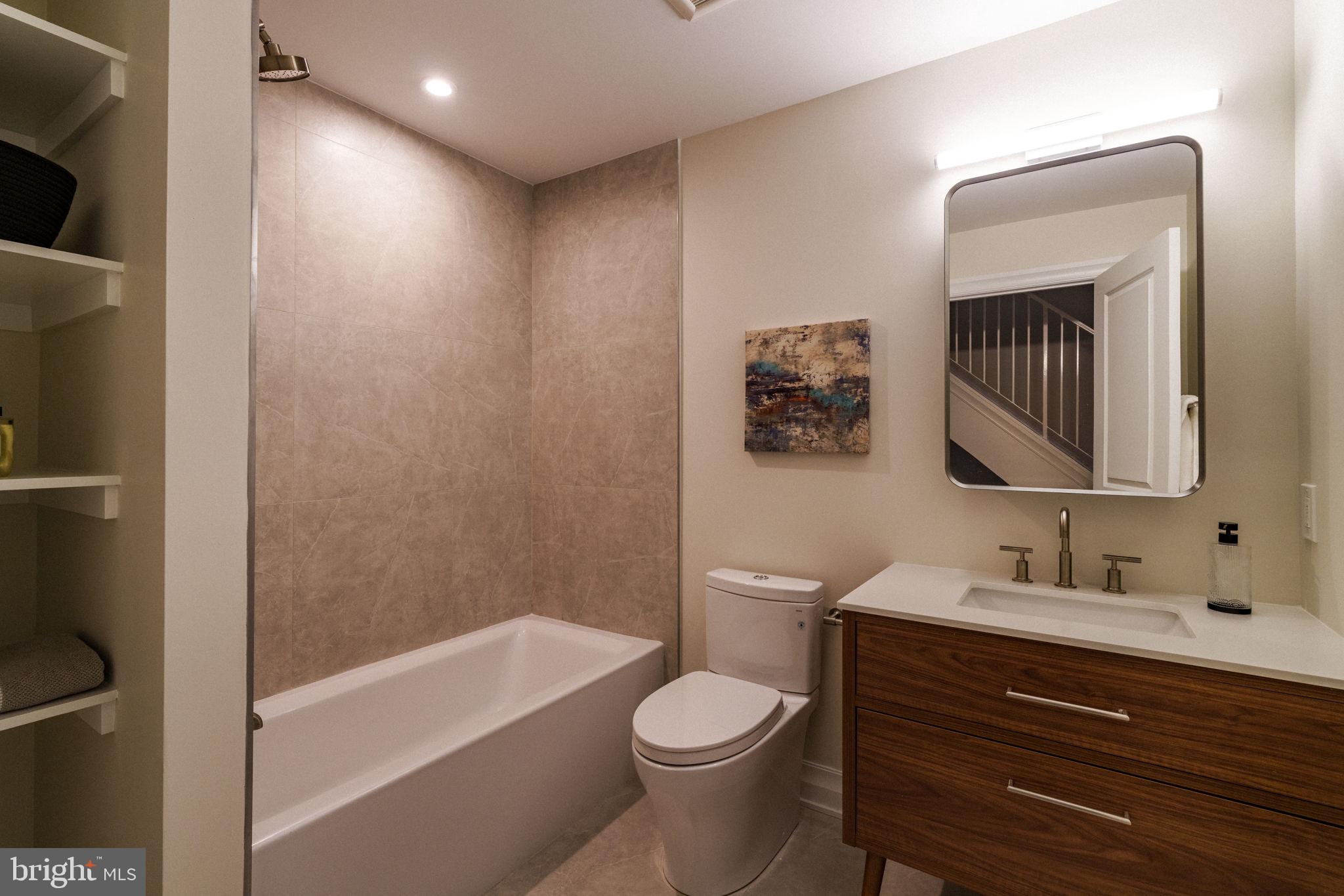 2104 Naudain Street Philadelphia, PA 19146 - Photo 20 of 56 a bathroom with a toilet a sink a mirror a bathtub and vanity