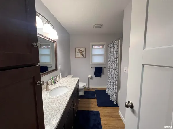 a living room with a floor to ceiling window and chairs