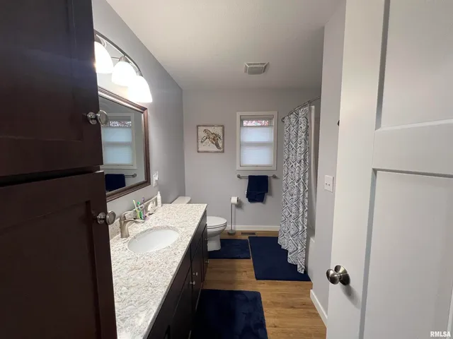 a living room with a floor to ceiling window and chairs