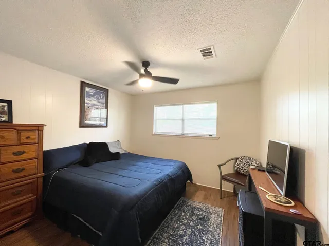 a bedroom with a bed window and a flat screen tv
