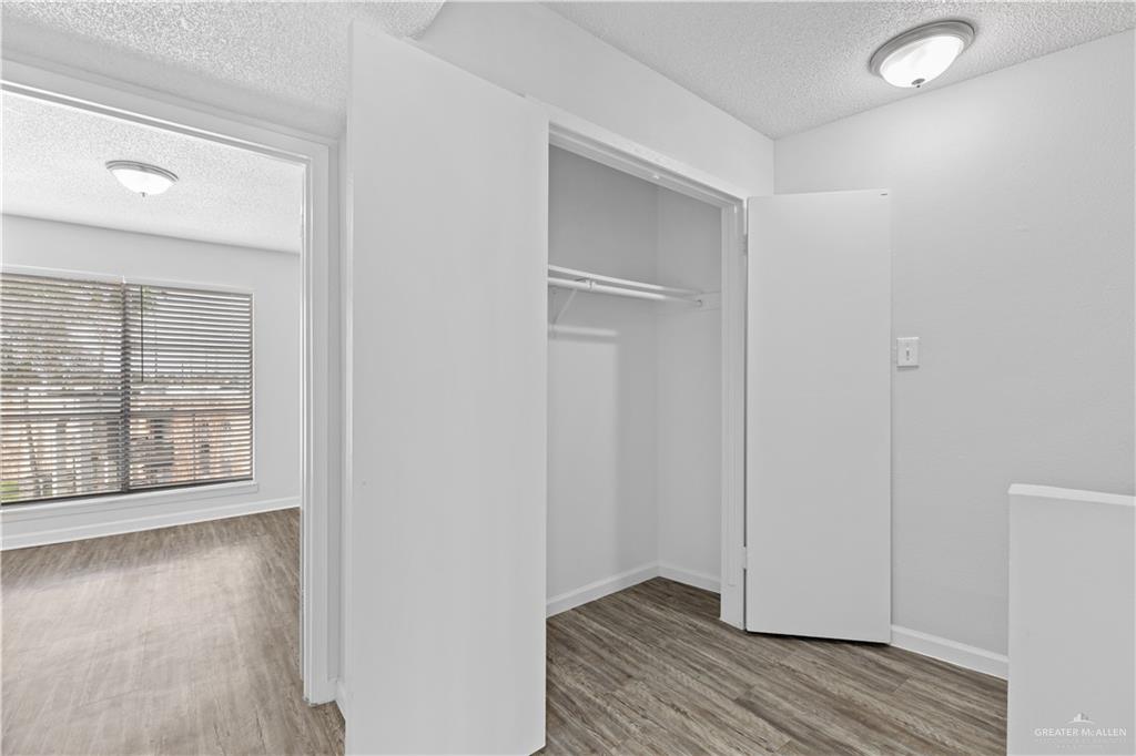 2425 Barnard Road, Unit 6C Brownsville, TX 78520 - Photo 2 of 15 Stairs featuring dark wood-type flooring and a textured ceiling
