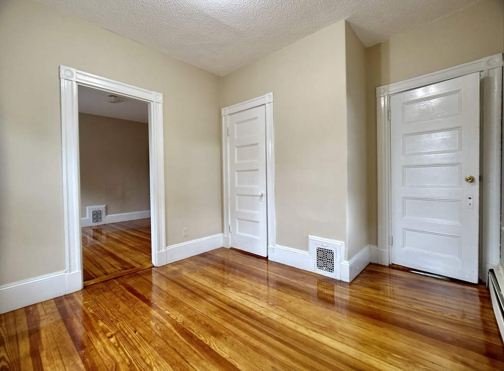 22 Spring Park Avenue, Unit 3 Boston, MA 02130 - Photo 4 of 11 a view of empty room with wooden floor