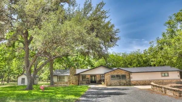 a front view of a house with a yard and an trees