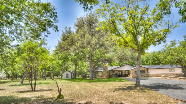 a view of a patio with table and chairs potted plants and large tree