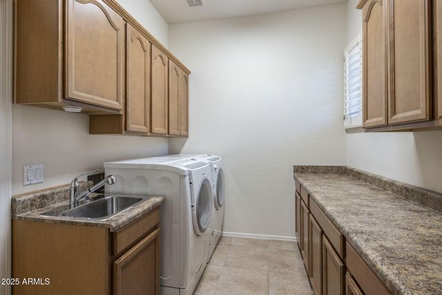 a utility room with granite countertop a sink a washer and dryer