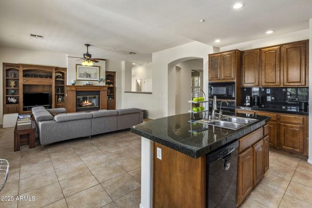 a kitchen with kitchen island granite countertop a sink a counter top space appliances and cabinets