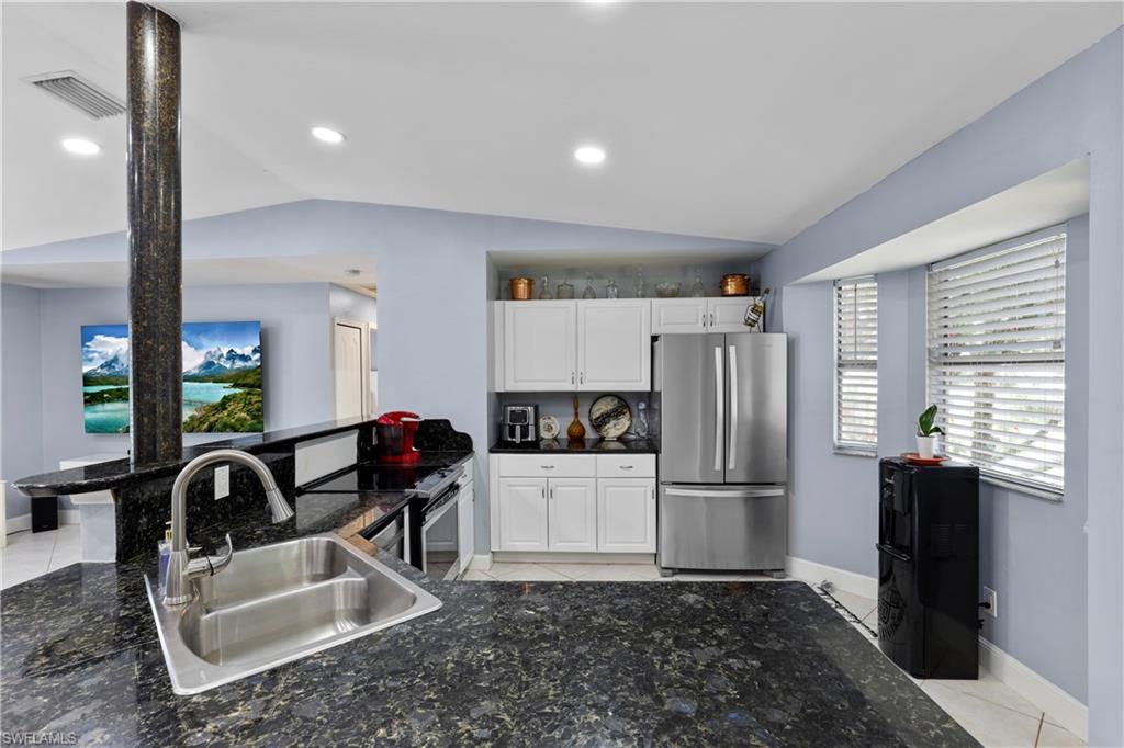 4641 Pine Ridge Road Naples, FL 34119 - Photo 16 of 30 a kitchen with granite countertop a refrigerator and a sink
