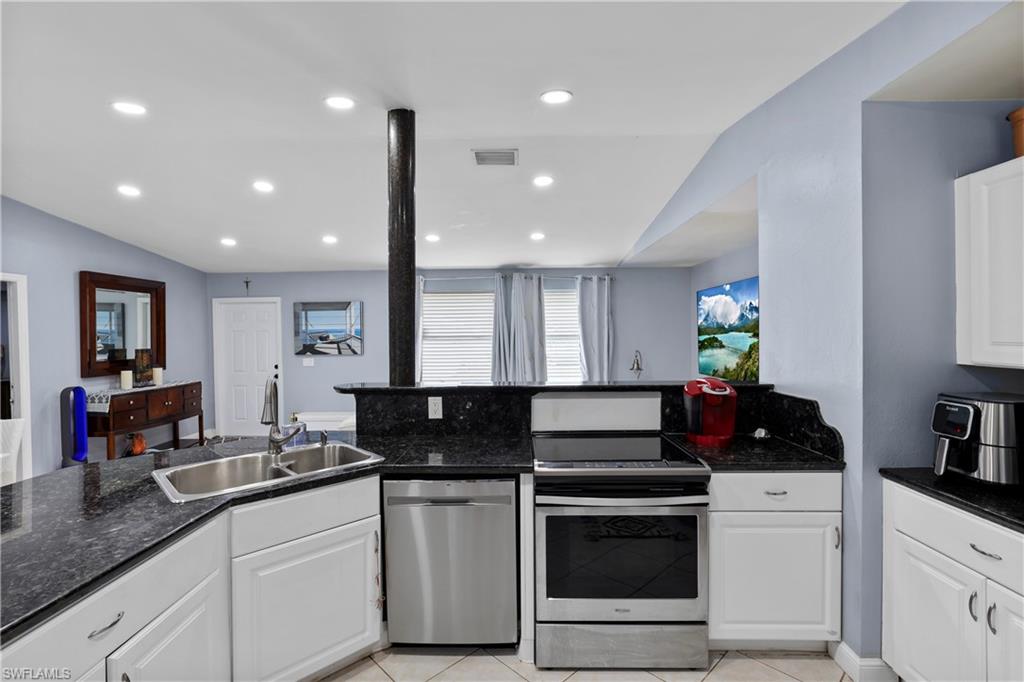 4641 Pine Ridge Road Naples, FL 34119 - Photo 17 of 30 a kitchen with granite countertop white cabinets and white appliances
