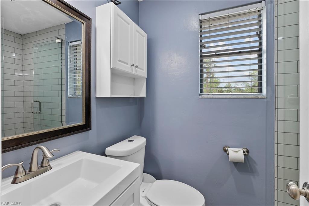 4641 Pine Ridge Road Naples, FL 34119 - Photo 19 of 30 a bathroom with a toilet sink and mirror
