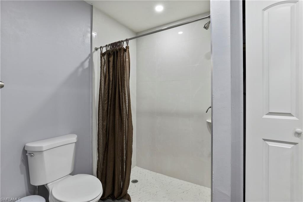 4641 Pine Ridge Road Naples, FL 34119 - Photo 20 of 30 a bathroom with a toilet and a shower