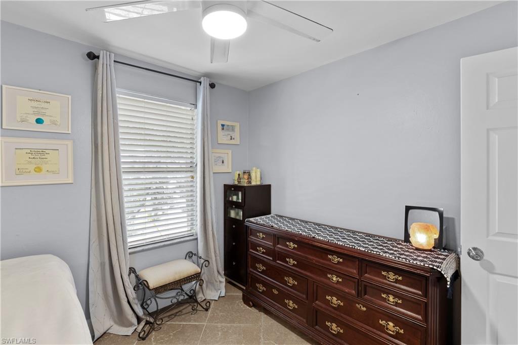 4641 Pine Ridge Road Naples, FL 34119 - Photo 21 of 30 a bedroom with a bed and wooden floor