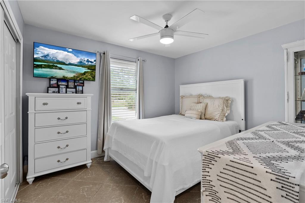 4641 Pine Ridge Road Naples, FL 34119 - Photo 7 of 30 a bedroom with a bed and a flat screen tv