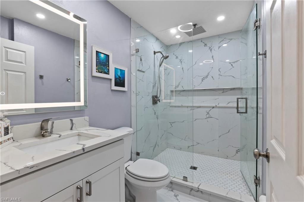4641 Pine Ridge Road Naples, FL 34119 - Photo 8 of 30 a bathroom with a sink a toilet and shower