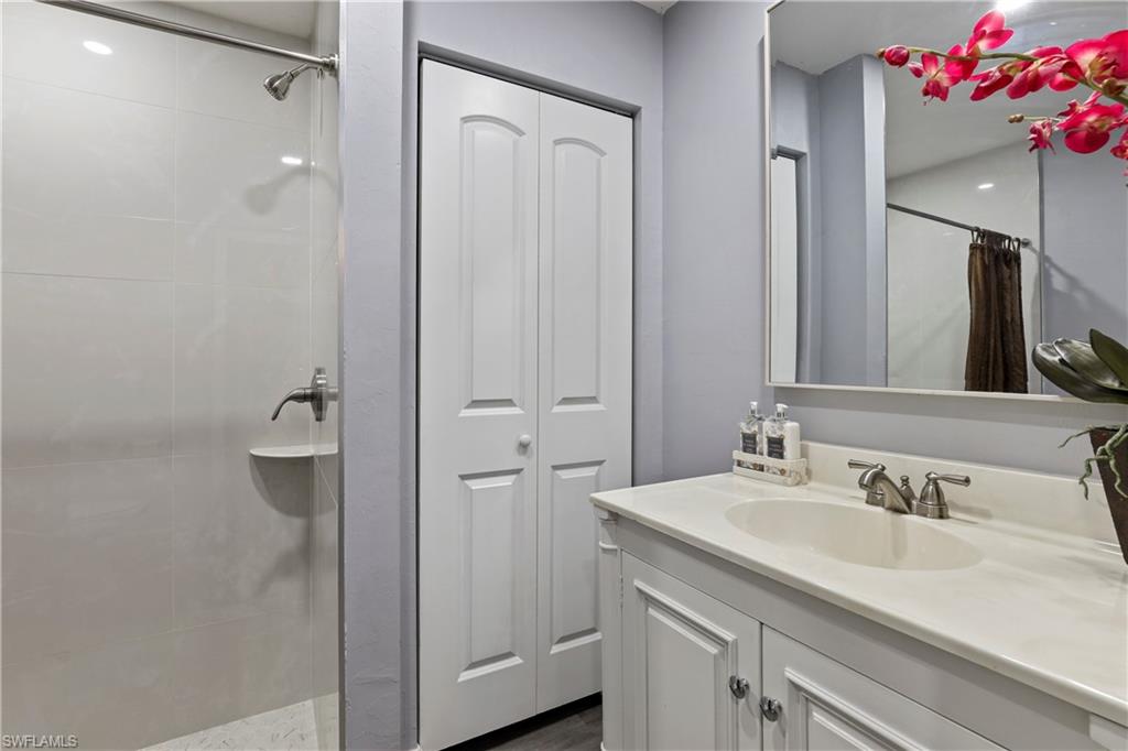 4641 Pine Ridge Road Naples, FL 34119 - Photo 10 of 30 a bathroom with a sink vanity and mirror