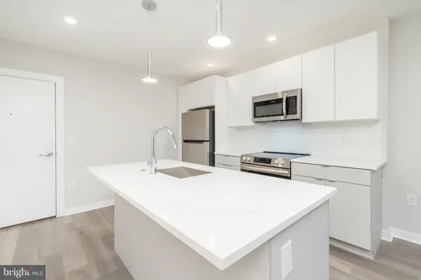a kitchen with stainless steel appliances a microwave a sink and a refrigerator
