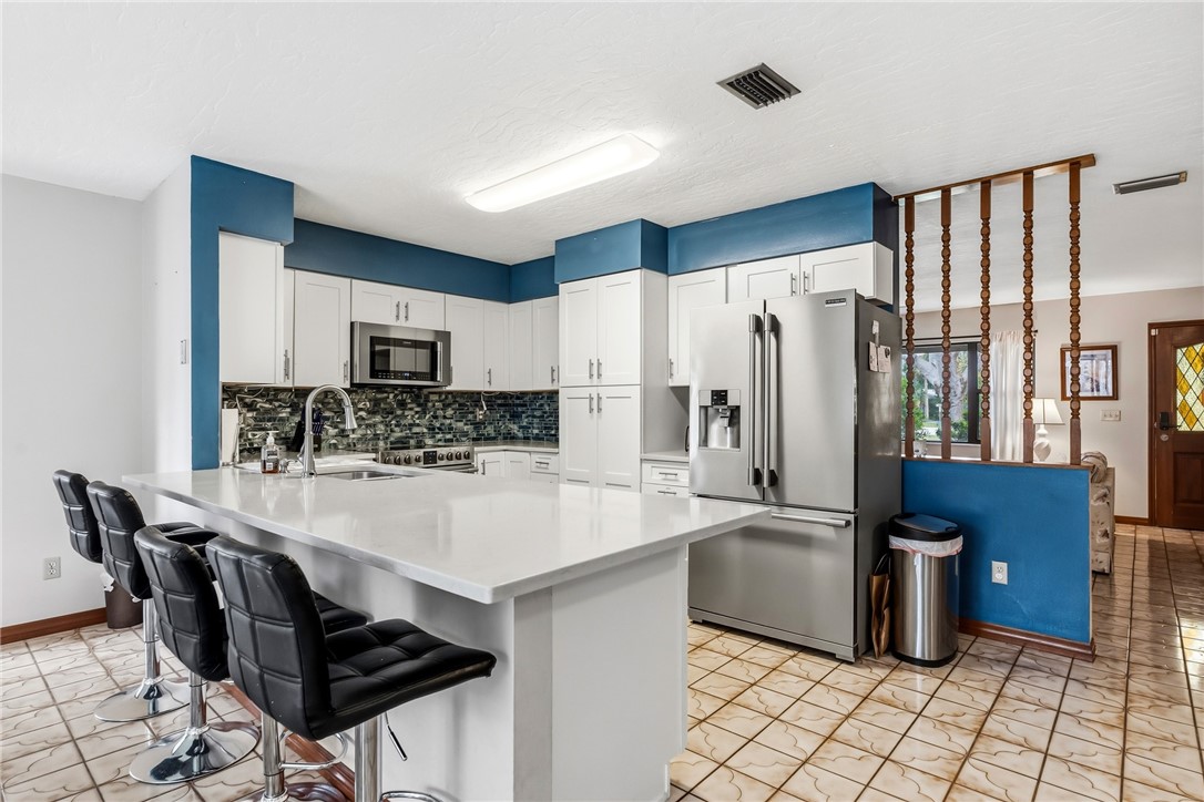 831 Clearmont Street Sebastian, FL 32958 - Photo 12 of 24 a kitchen with stainless steel appliances a refrigerator sink and stove