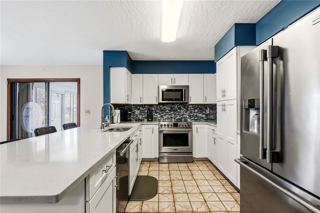 831 Clearmont Street Sebastian, FL 32958 - Photo 13 of 24 a kitchen with stainless steel appliances a refrigerator sink and stove