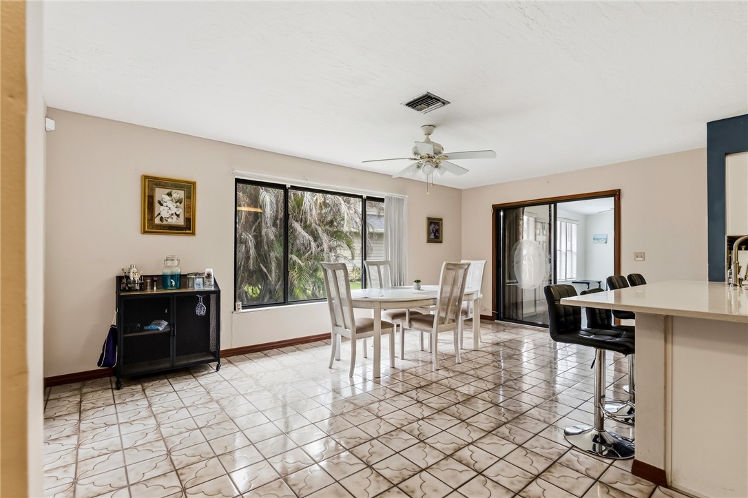 831 Clearmont Street Sebastian, FL 32958 - Photo 14 of 24 a living room with furniture a flat screen tv and a floor to ceiling window