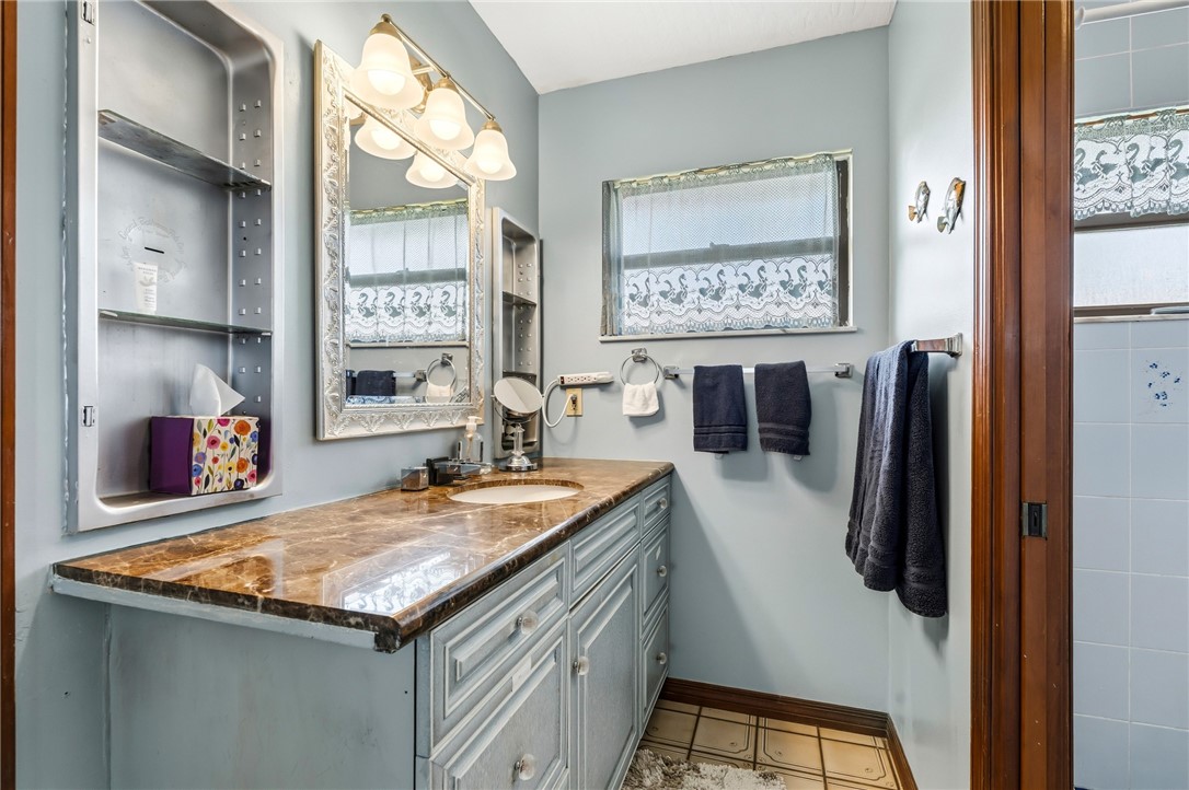 831 Clearmont Street Sebastian, FL 32958 - Photo 18 of 24 a bathroom with a granite countertop sink and a mirror