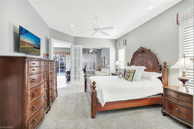 a bedroom with a bed a flat tv screen and dresser