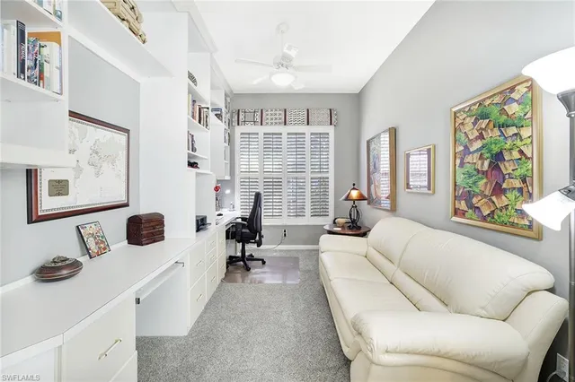 a living room with furniture large window and wall painting