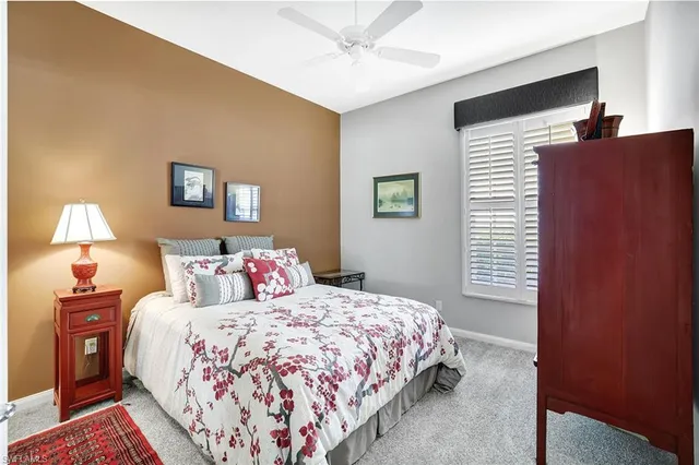 a bedroom with a bed and a lamp on dresser