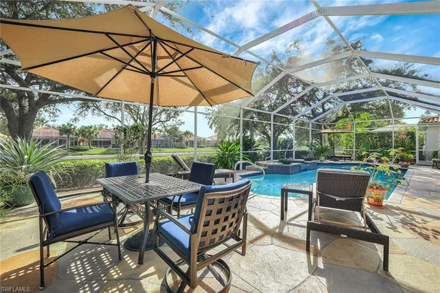 a view of a patio with a table and chairs under an umbrella