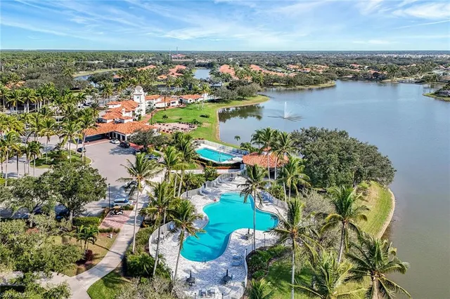 an aerial view of city and lake with trees