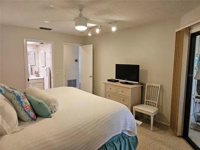 a bedroom with a large bed and a chandelier