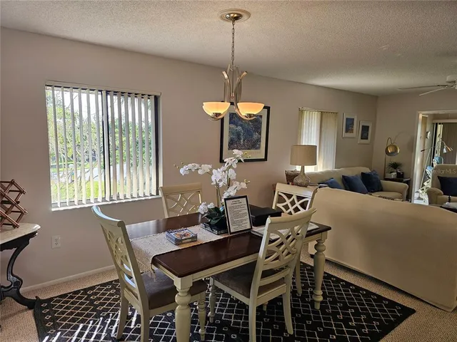 a living room with furniture a flat screen tv and a chandelier
