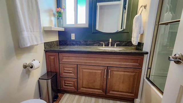 a bed sitting in a bedroom next to a window and dresser