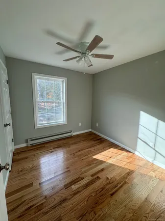 a view of empty room with wooden floor