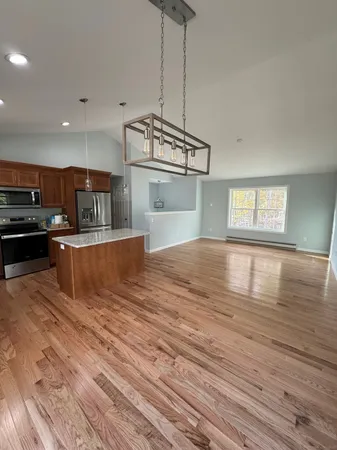 a kitchen with stainless steel appliances granite countertop a stove and a wooden floors