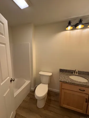 a bathroom with a granite countertop toilet and a sink