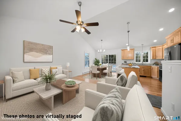 a living room with furniture kitchen view and a chandelier
