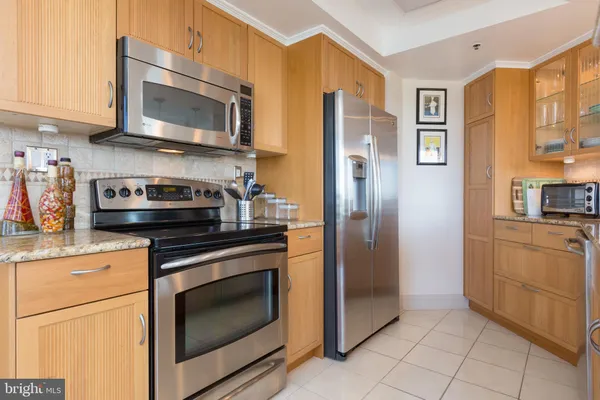 a kitchen with stainless steel appliances granite countertop a refrigerator stove and sink