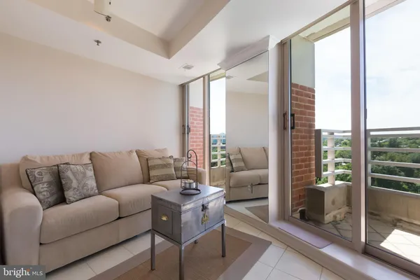 a living room with furniture and a floor to ceiling window