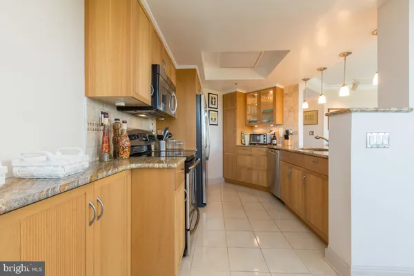 a kitchen with stainless steel appliances granite countertop a stove a sink and a refrigerator