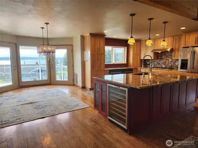 a kitchen with kitchen island granite countertop a sink stove and cabinets