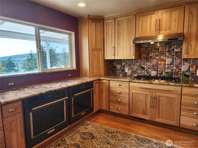 a kitchen with granite countertop a sink stainless steel appliances and cabinets
