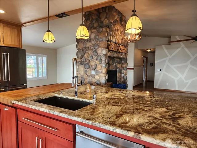 a view of a kitchen with living room and chandelier