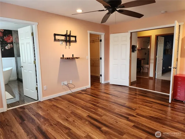 a view of a livingroom with wooden floor and a ceiling fan