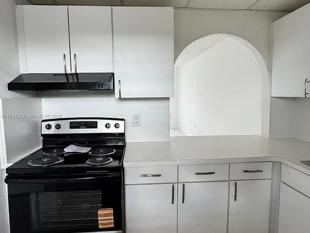 a stove top oven sitting inside of a kitchen