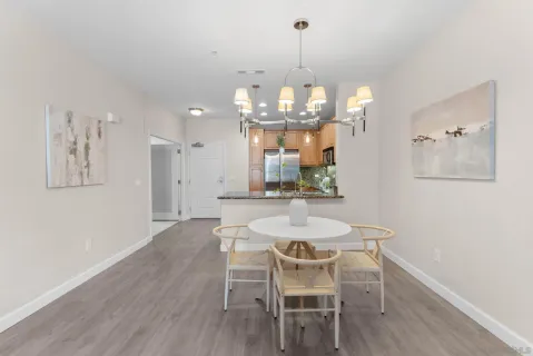 a view of a dining room with furniture a chandelier and wooden floor