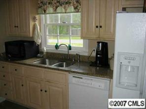 320 Jim Parker Road Monroe, NC 28110 - Photo 5 of 8 a kitchen with granite countertop a sink a stove and cabinets