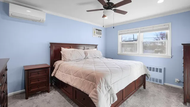 a bedroom with a bed chandelier and a window