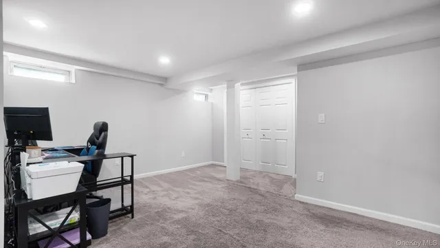 a view of a workspace with furniture and a window