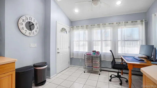 a view of a workspace with furniture and a window