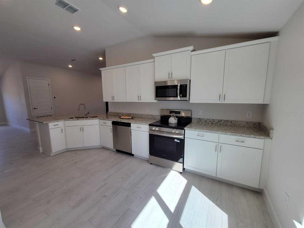 4465 Southwest 91st Ln Road Ocala, FL 34476 - Photo 9 of 42 a kitchen with stainless steel appliances kitchen island granite countertop a sink and cabinets