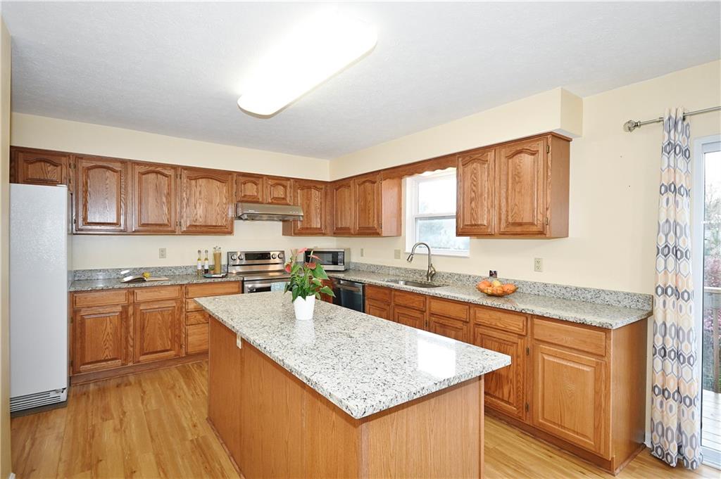 1076 Rural Ridge Drive Cheswick, PA 15024 - Photo 11 of 37 a kitchen with stainless steel appliances granite countertop a sink stove cabinets and wooden floor